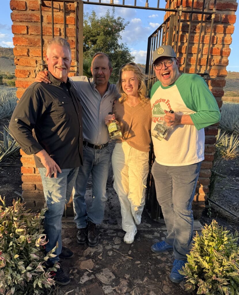 Group of people smiling with liquor bottles